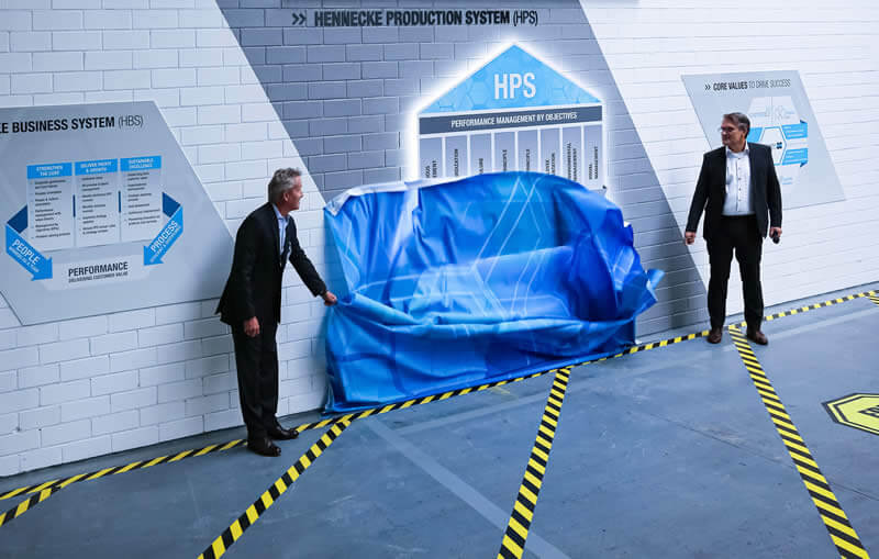 Unveiling the HPS depiction at the inauguration of the new production system by Rolf Friedli, Chairman of the Advisory Board Hennecke GROUP and Thomas Wildt, CEO Hennecke GROUP (from L to R)